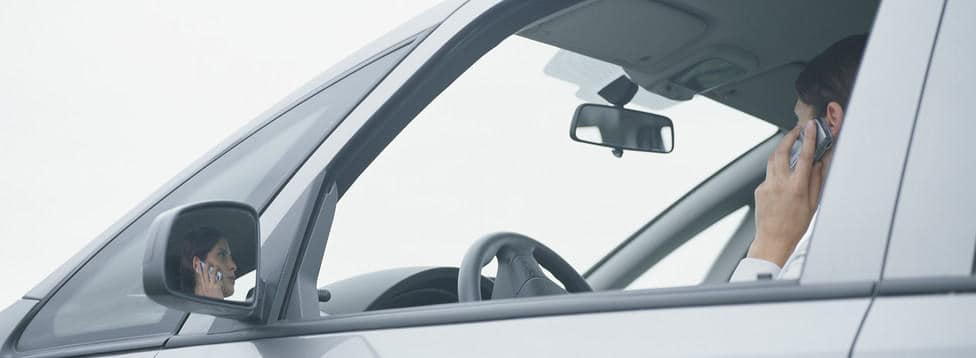 Frau spricht am Telefon während Observation im Auto.
